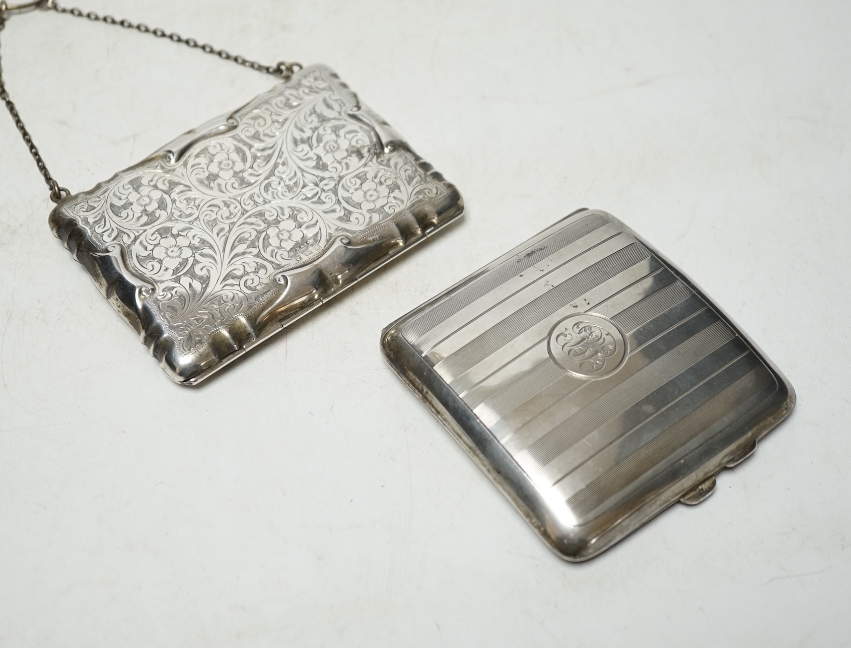 A George V silver cigarette case, 94mm and a George V engraved silver purse (lacking insides). Condition - poor to fair